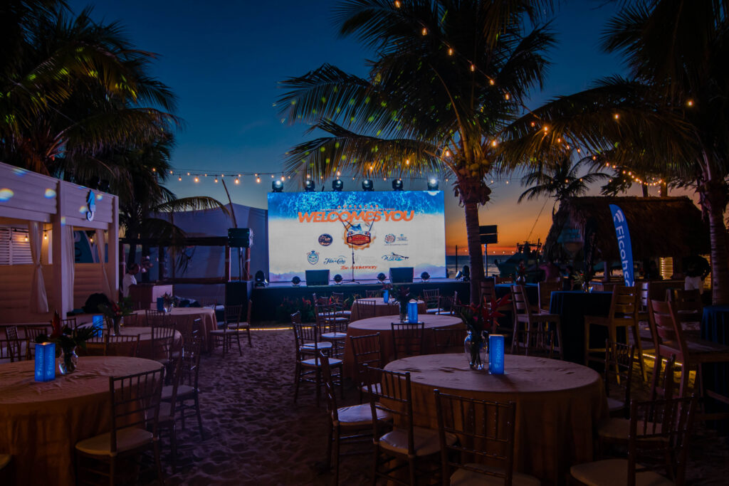 Beachfront event stage at dusk with string lights